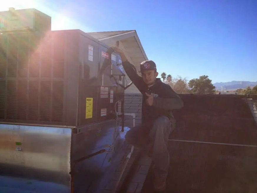 HVAC technician performing Heat Pump Repair on a rooftop unit in Silver City